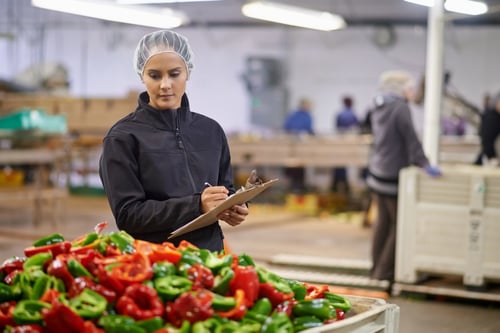 Logistics employee filling out a time-consuming produce inspection checklist