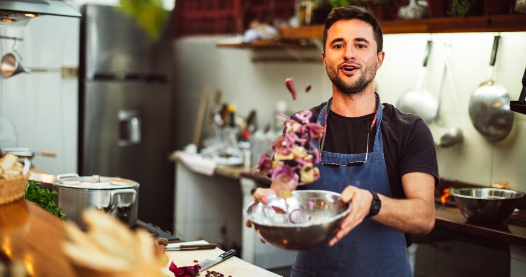 Restaurant employee tossing salad