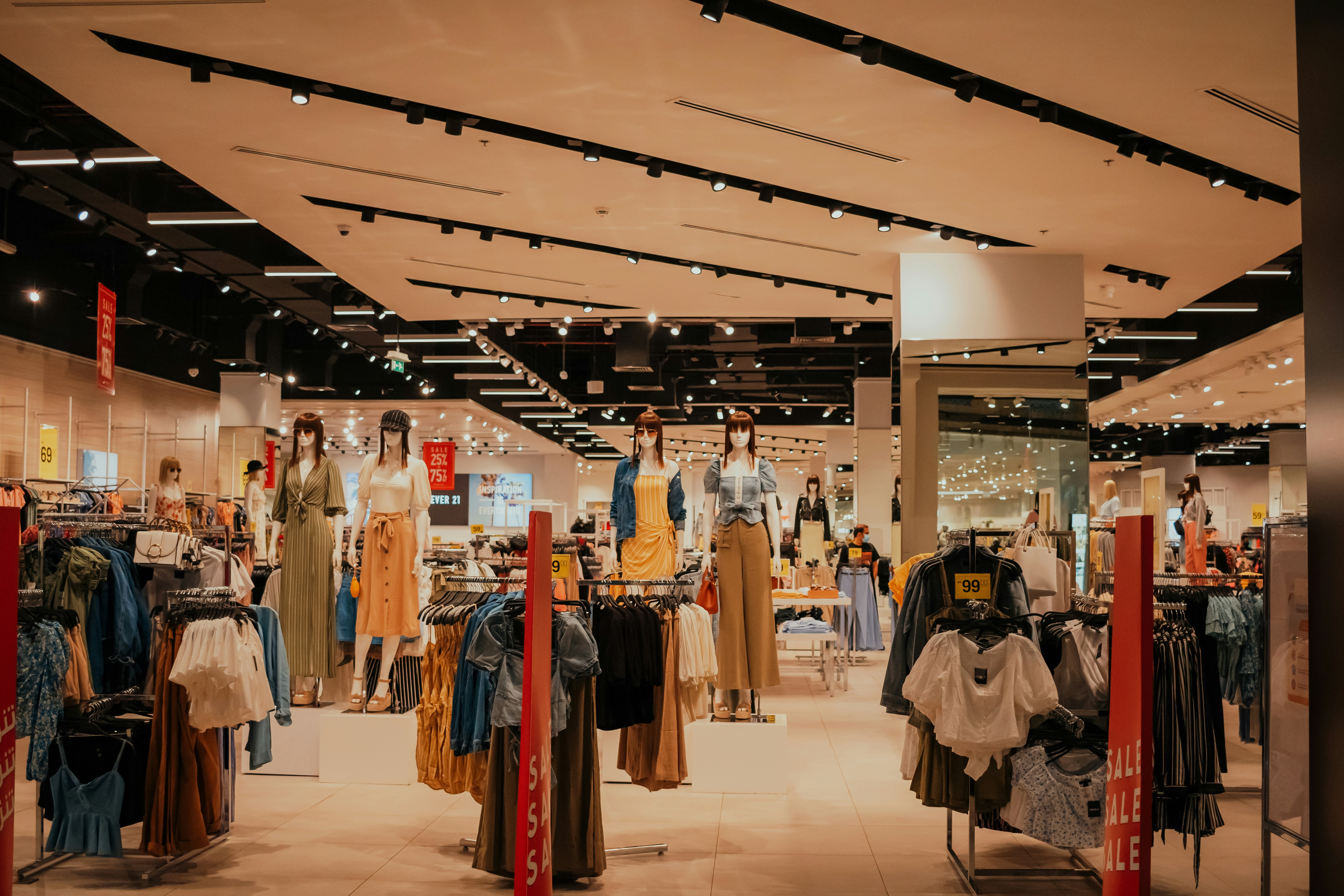 Clothing store interior with mannequins and sale racks, bright and inviting retail space.