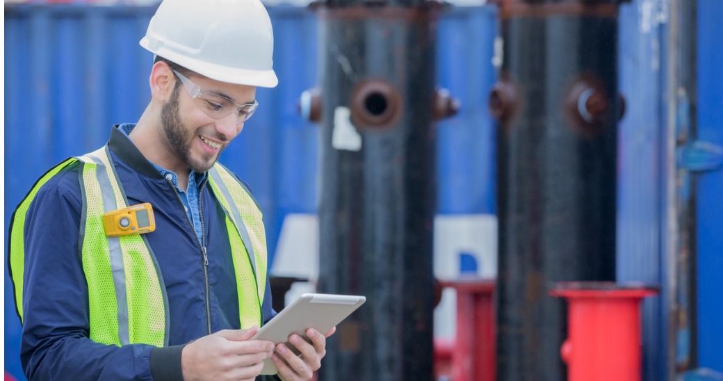 Engaged engineer reading internal communications updates on a tablet